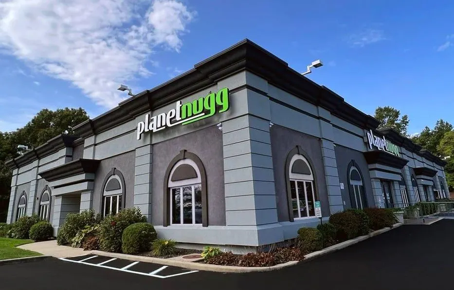 Planet Nugg dispensary exterior with green sign and arched windows in Farmingdale
